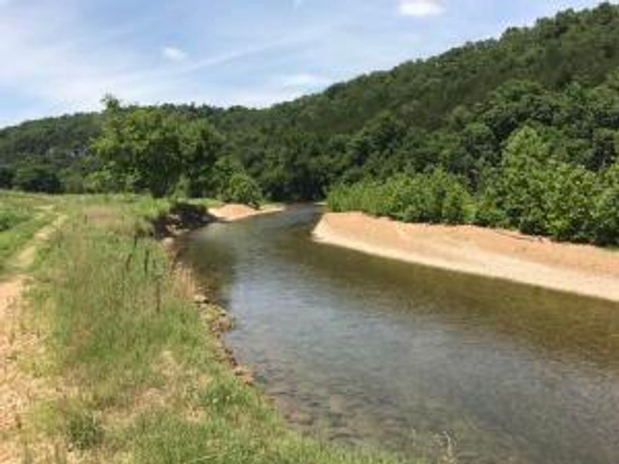 No prettier stream in all of north Arkansas, Crooked Creek. This Premier Blue Ribbon Smallmouth Bass Stream flows year round through approximately 1 1/2 miles of this beautiful property. Approx. 175 acres in nice pasture and hay meadows. Some Marketable timber with beautiful bluffs and awesome private views. Some bottom land but mostly out of flood area. Pond and two other springs. Electricity on property with two wells and homesites. Fenced and cross fenced for nice cattle, horse  farm or development property. Only one mile off of Hwy 65. 20 minutes to Harrison and shopping. One hour to Branson, MO. Link to nice You Tube Video on farm. Go to Photos above and click Video B.