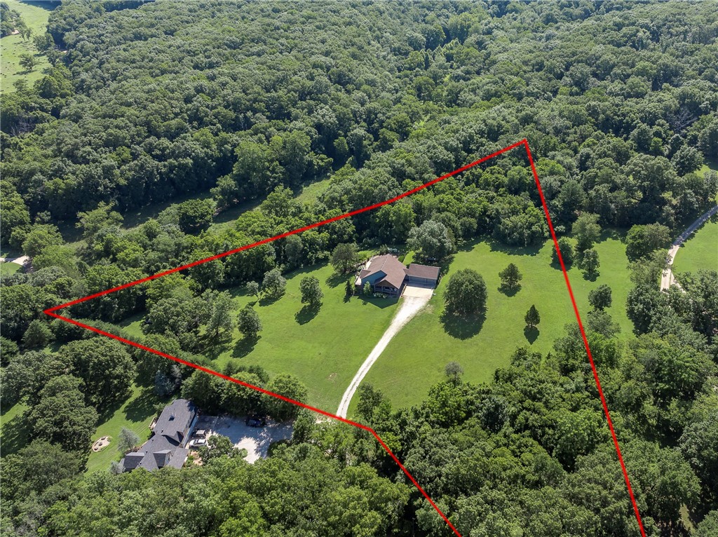 Rare chance to own 5 private, wooded acres just minutes from Bentonville! This spacious 3534 SF home is move-in ready with an inviting in-ground pool, large scenic deck, and covered front porch perfect for entertaining or relaxing in nature. Modern kitchen features quartz counters, gas range, custom cabinetry, and island seating. Vaulted living area with panoramic views and abundant light. Luxurious primary suite with private balcony, walk-in closet, spa-like bath with double vanities, tiled shower, and sauna. Finished walk-out basement offers a large family room, full bar with seating, game area, and extra bedrooms for guests or office. Landscaped yard with mature trees ensures privacy. Oversized laundry room with built-ins, attached 3-car garage, and ample storage throughout. Ideal for buyers wanting acreage, space, and seclusion without giving up quick access to Bentonville schools, shopping, trails, and all Northwest Arkansas amenities.