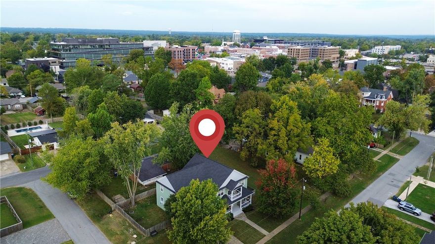 Welcome to 310 SE C Street, where timeless character meets the pulse of downtown Bentonville living. Perfectly positioned in the heart of it all, this home sits steps from the Square,Momentary, 8th Street Market- all that city living has to offer.  Fully reimagined by Dave Marrs in approx 2012, this residence blends historic warmth with modern comfort. A covered front porch sets a tone, leading to spacious living areas ideal for gathering. The kitchen features granite countertops, custom cabinetry, and connection to the formal dining room perfect for hosting. The oversized primary suite is a retreat: sitting area, spacious ensuite, private patio for quiet mornings & relaxing evenings. 3 additional rooms + an office/flex room offer versatility. Oversized garage is an added convenience. Located in one of Bentonville’s most coveted areas, this home captures the best of downtown living — walkable, welcoming, and effortlessly livable. Seller offering a $10,000 paint allowance to personalize this exceptional home.