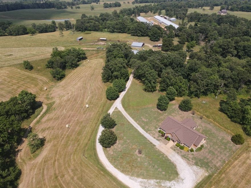 A cattlemen's dream.  The 125 Acres boasts pastures that are fenced and cross fenced into 4 fields each with their own holding pen that connects to the corrals.  The corral system is complete with a covered head chute and a loading pen.  After working your cattle you can relax in your gorgeous 3 bed 2 bath home with wonderful custom touches, split floor plan, a large covered patio for your evening enjoyment and a beautiful view from every window.  The home is also handicap accessible. There is a 3200 sq ft shop, with a wood stove, air compressor, an office, loft storage and more.  On the property you will also find a 1600 sq ft covered implement shed.   After taking care of the cattle you can go over to the South West part of the property to approx 40 wooded acres and do a little hunting.  Deer and turkey are plentiful. This farm truly has it all.