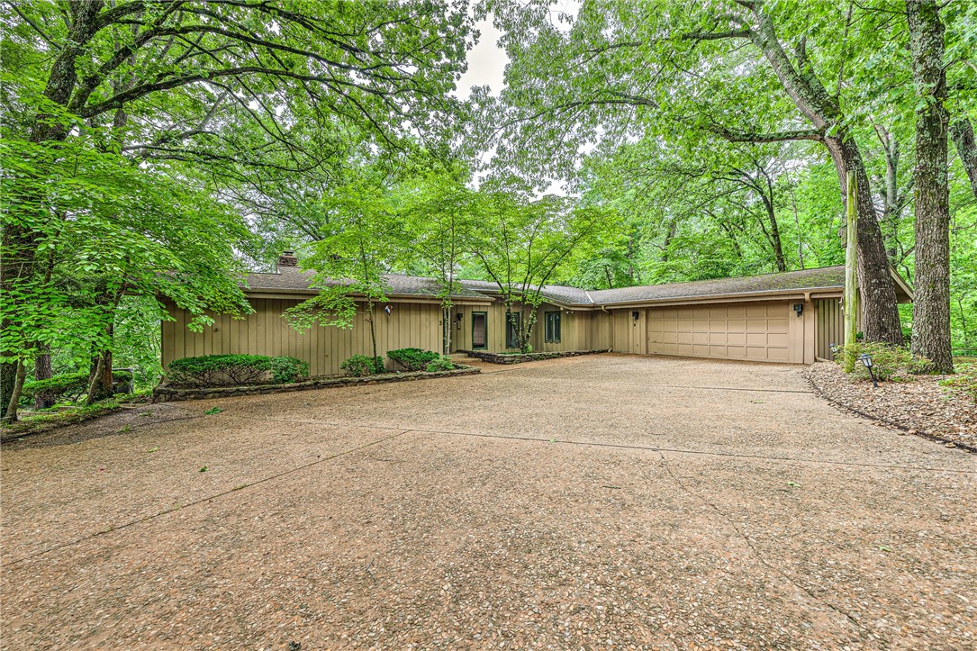 Play where you live! This epic Mid-Century Modern masterpiece in Bella Vista offers golf front, mountain bike trails, and creekside living. Perched on an oversized corner lot in a quiet cul-de-sac, this 4-bedroom, 3.5-bath home offers elevated, birds-eye views of Berksdale Golf Course’s 2nd hole, the peaceful sounds of Little Sugar Creek, and direct access to the Tunnel Vision mountain bike trail. Blending timeless architectural design with the natural beauty of its surroundings, the home is nestled among mature trees, providing both privacy and stunning scenery. Whether you're an outdoor enthusiast, design lover, or simply seeking a serene retreat, this home offers the best of Bella Vista living. Don’t miss the opportunity to own a true architectural gem in one of the area’s most scenic and convenient locations.