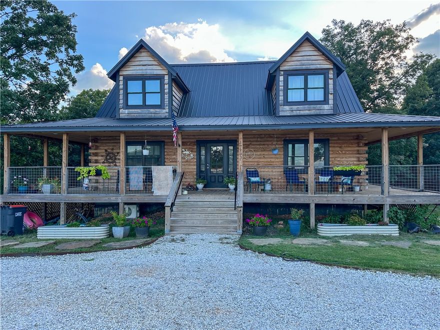 Beautiful custom log home on 2.5 acres just few miles north of Pea Ridge, one of NWA's great communities. Home has 3 levels, vaulted main living area, finished walkout basement which is a separate living area and is used as an AirBNB rental. Could be an apartment or extended family home. Huge wrap around covered porch on three sides, over 900 sq ft,  looks over the above ground pool, shop and recreation area. Most of the furniture will convey. 40x60x12 red iron insulated shop with an 800 sq ft appt also used as AirBNB and/or apartment rental. Shop has 3 10x10 doors, 2 walk in doors and a 20x60 covered cement area in front of the shop with pickle ball and volleyball court. Truck lift doesn’t convey but can be purchased. Looking for a great country place that's not far from everything NWA, come check this out!! Bike riding starts here!!