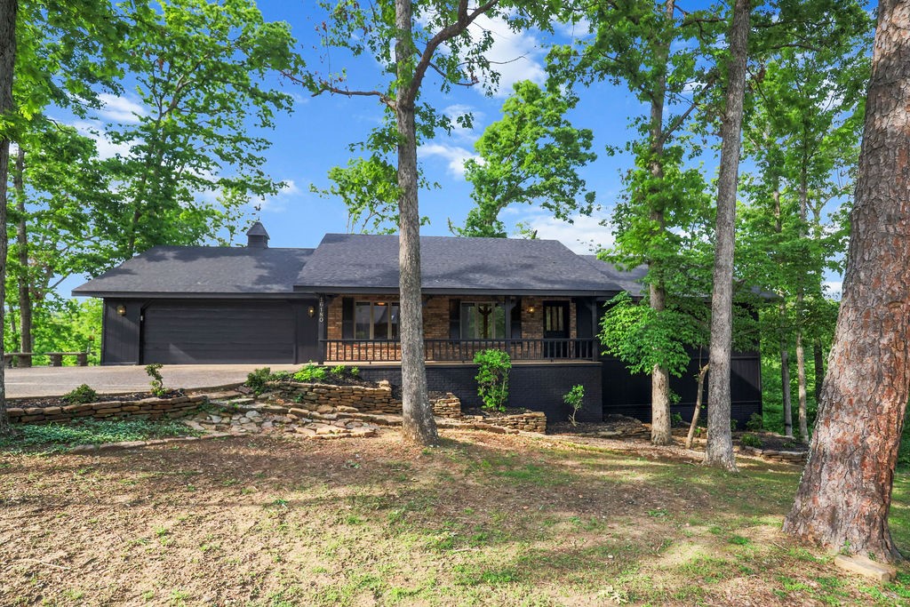 Lakefront Luxury! Meticulously maintained 4-bed, 3-bath home with recent upgrades: new roof, fresh exterior paint, and professionally landscaped grounds. Enjoy lake living with a private boat dock (1 slip included; neighbor shares expenses for the 2nd), two WaveRunner spots, and a swim deck for summer fun. Inside features real wood floors, granite counters, Bosch appliances, and a flexible layout with two living areas—each with charming wood-burning fireplaces. The primary level offers lake views from multiple decks (screened porch included), while the lower level has a fireplace with whole-house heating ducts for cozy winters. Renovations include 3 remodeled bathrooms, a spacious laundry room, and workshop area. All furniture, towels, sheets, and glassware convey! Currently a successful short term rental; this all-electric home includes central vac, 200-amp service, and double-pane windows. Lakefront serenity meets modern comfort—your dream retreat awaits!