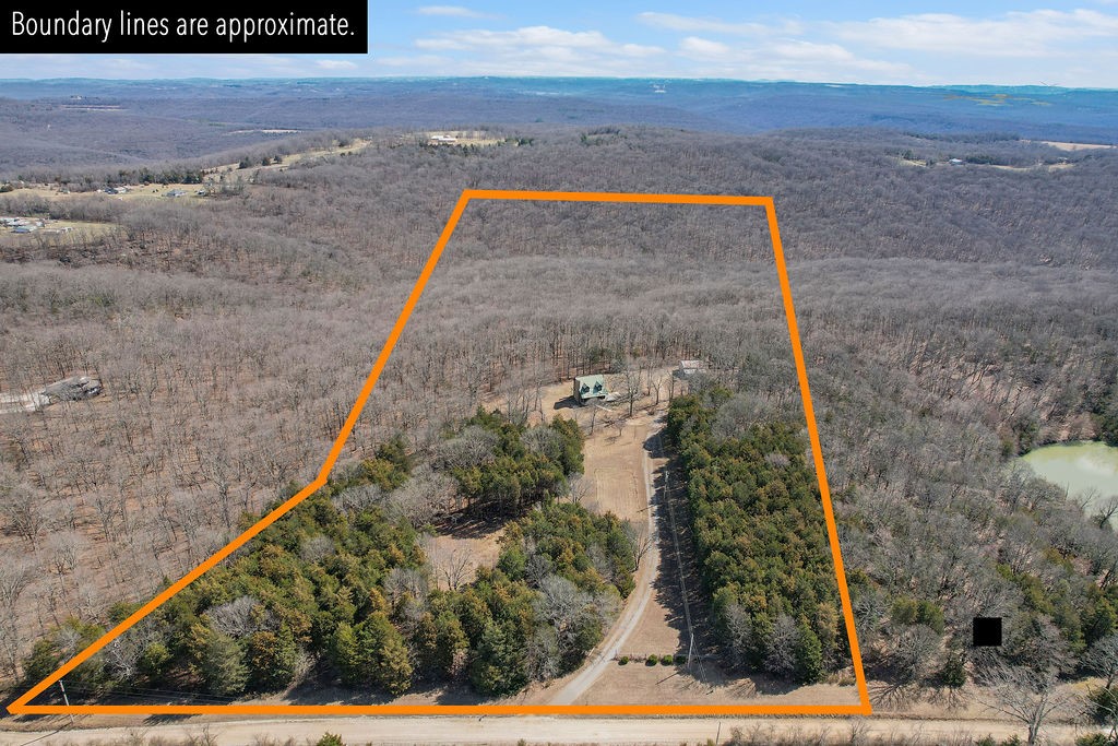Must see this charming 3 story house in the heart of the Ozark Mountains! The main level features a cathedral ceiling, a stunning rock fireplace with efficient wood burning insert- perfect for those cozy winter nights. Step out of your kitchen onto the deck to enjoy your morning coffee & watch the deer. The main level master bedroom has a walk-in closet, spacious bathroom, shower, double vanity sink, & washer/dryer hookups. Upstairs has a large bedroom with beautiful wooded views, walk-in closet, a common area perfect for a game room, and large bathroom with a shower. The finished basement has a beautiful rock alcove for a wood burning stove, large open room great for a man cave of your dreams, a bedroom & bathroom that’s ready for your design ideas! The property has 2 open acres with electric and internet connections installed. The large metal barn on the property is excellent for storing your ATVs, boat, or small camper and complete with electric, water and internet connections. Don't miss out on this one!