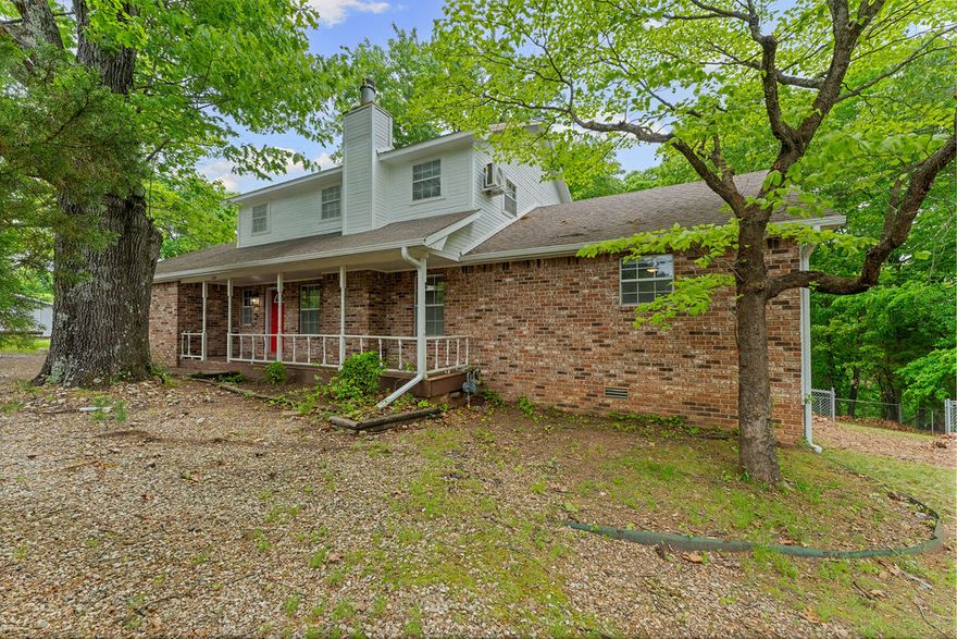 Tucked away on over half an acre just minutes from Prairie Creek Marina Recreational Area and only 4 minutes to downtown Rogers, this home offers the perfect blend of space, comfort, and a peaceful, nature-filled setting. Surrounded by mature trees, you’ll love starting your mornings on the front porch with a cup of coffee, soaking in the quiet and privacy that feels miles away from the city.  Inside, this 5 bedroom, 4.5 bath home offers generous living space.  The spacious living room flows right off the kitchen, creating a great setup for both everyday living and entertaining.
Step out back to a large deck where you can unwind in the evenings, enjoy the wooded views, and listen to the sounds of nature. With close proximity to the lake and all the outdoor recreation it offers, this property is a rare opportunity to enjoy a relaxed, tucked-away lifestyle without sacrificing convenience.  Property is also equipped with 200 Amp electrical service and septic clean out for RV Parking
