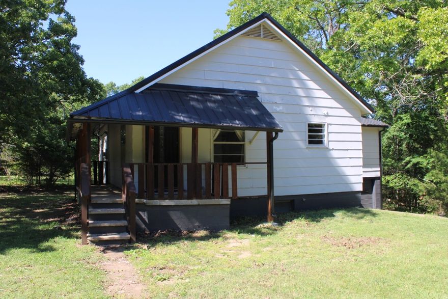 Very Near Bull Shoals Lake - enjoy the partial wrap-around porch, large living room, kitchen-dine combo, and large primary bedroom. Property includes 2 near level lots only a few minutes to Bull Shoals Lake known for water sports and fishing. Home has new metal roof installed in 2025, newer central heat & air units, and several other updates, continue updates to buyers preference. Full basement includes one car garage and offers lots of storage along with easy access to plumbing, etc, basement does have seepage in rainfall time but sump pump and de-humidifier removes moisture in short time. Two nice lots with 10 x 13 storage building, lots of shade trees and privacy, only a few minutes to Corp of Engineers maintained park and marina on Lake Bull Shoals. Seller has two extra lots available that join on the west side of this property for additional $4,500. Come See Soon!!