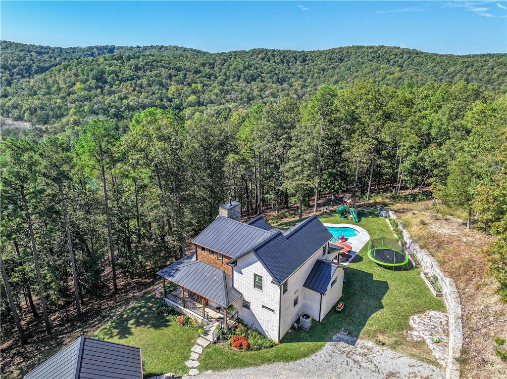Dazzling modern farmhouse on Big Clifty arm of Beaver Lake! From the brick and cedar shake exterior to the light and soaring interior, and out back to the spacious gathering space around the heated in-ground freshwater pool, there is nothing missing from this complete package home. The vaulted great room with wood-burning fireplace invites cozy as well as large gatherings. Scraped Hickory floors complemented with tile in the wet spaces, well-appointed eat-in kitchen, master bedroom suite and combination laundry/pantry/mudroom on main floor. Generous covered porches provide extra room for enjoying the outdoors and for entertaining, with a huge, covered patio area next to the pool. The three-car garage can hold your vehicles and toys, with extra attic storage. Public boat ramp just minutes away!