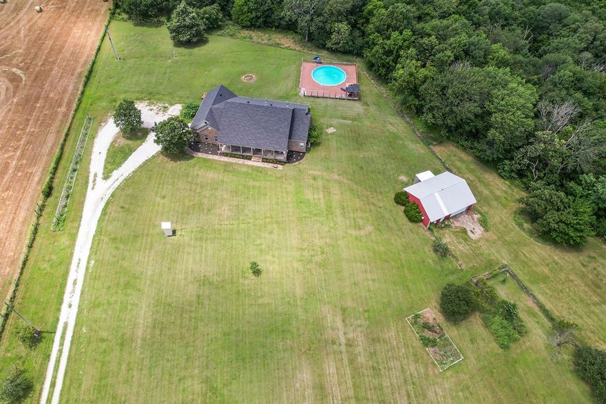 Welcome to your slice of country paradise—just minutes from downtown Prairie Grove! Enjoy peaceful living on spacious land with all the comforts of home. The generous layout features a fully equipped kitchen with granite island, double ovens, full-size fridge, and ample storage. A large bonus room offers space for a home theater, office, or studio. Major recent upgrades include: new five-ton HVAC, water filtration system, new pool liner, new pool deck, new roof. Step outside to your private oasis with a sparkling pool perfect for summer fun. The barn/shop, while needing some tlc, offers room for hobbies, storage, or business use. Additional utility hookups on the far end of the land are ideal for future expansion-rental or workshop. The flat, fertile property is dotted with mature apple, peach, and cherry trees and offers great potential for farming, gardening, or development. Pre-qualification letter or proof of funds required with offer. Indoor cats are on-site and must stay in their designated room.
