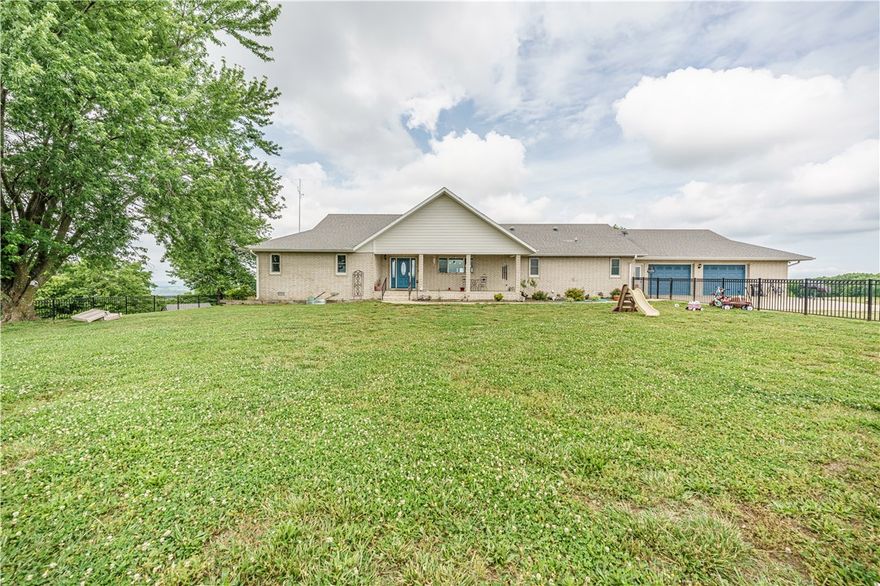 Country living in this 3,854 sq ft brick home atop 87 acres with an exceptional, long-range view. Designed for comfort and entertaining, this property blends refined finishes with practical amenities—inside and out. 4 spacious bdrms, 2 full baths, and 2 half baths. Open living room with floor-to-ceiling windows and a wood-burning fireplace. Kitchen featuring granite countertops, a huge island, and an oversized pantry. Primary suite has a large walk-in shower and a walk-in closet. Oak built-ins throughout bdrm and bath for character and storage. Lower level includes a storm room, a sunroom, and an additional living area with a second wood-burning fireplace. 40x80 shop building with partial concrete flooring—perfect for equipment, hobbies, or a home business. 20x40 equip shed for added storage. 87 acres offering privacy, recreation, and breathtaking sunset views. From its light-filled interiors to its outbuildings and sweeping acreage, this is a rare opportunity to own a home with room to grow, work, and play.