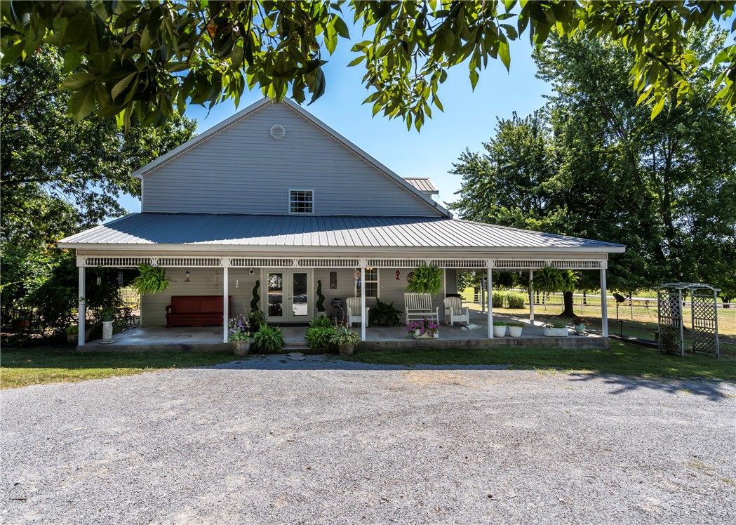 Two-story farmhouse on 15 acres! This 3-bed, 3-bath, 2,794sf home blends classic charm with rural serenity. The welcoming wrap-around porch leads into an open floor plan, perfect for entertaining. Kitchen has granite, gas cooktop, double wall ovens, dishwasher, & microwave/vent. Breakfast nook area & dining room. Primary bedroom, bath, & utility downstairs with fireplace in LR. Upstairs, you'll find a flexible bonus room, full bath, & guest rooms. Metal roof & vinyl exterior. The property is a mix of pasture & wooded acreage with pipe fencing, apple, & pear trees. 2 Shops with concrete floors & electric (one has 110), & a barn with six bays on each side provide extensive space for cars, projects, & storage. Basketball court with goal. Corrals convey. Frost-free hydrants. Located on a paved road just outside of town with a circle drive. City water, natural gas, & septic system. HVAC-appx 4yrs. Hot tub conveys. Survey needed-15 acres m/l.