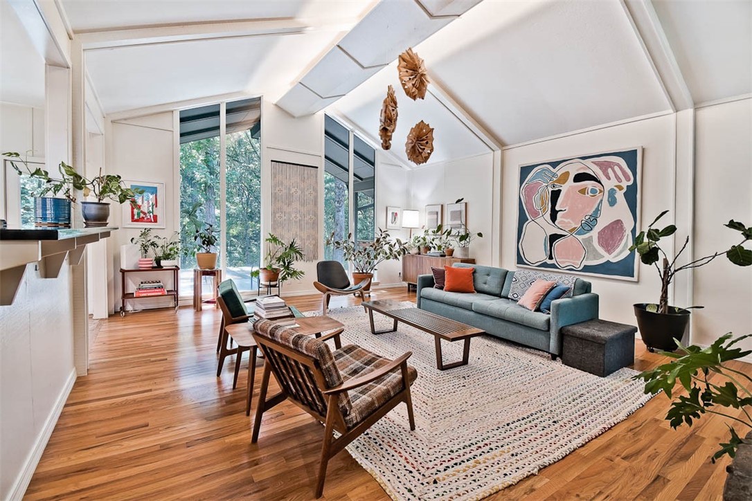 Showings for this updated midcentury home begin Friday, June 6th. Nestled on a private, park-like wooded lot in a quiet cul-de-sac, the home offers walkability to Gulley Park, local trails, and Butterfield Elem., with quick driving access to I-49 and Downtown/Dickson. Inside, you'll find 3 spacious living areas, including a stunning sunken living room with vaulted ceilings, a massive stone hearth, and views of the serene backyard. Near the primary suite is a 2nd living area flanked by two bedrooms and a shared bath—an ideal kids’ wing that can be closed off for privacy. On the opposite end of the home, a large light-filled bonus room features built-in shelves and snack bar area. Outdoor living is just as impressive, with a private deck off the primary suite, a large covered patio with vaulted ceiling off the main living area, and plenty of extra patio and deck space for relaxing, entertaining, or play. The 2-car carport has EV charging, additional uncovered parking area is also tucked out of view from the street.