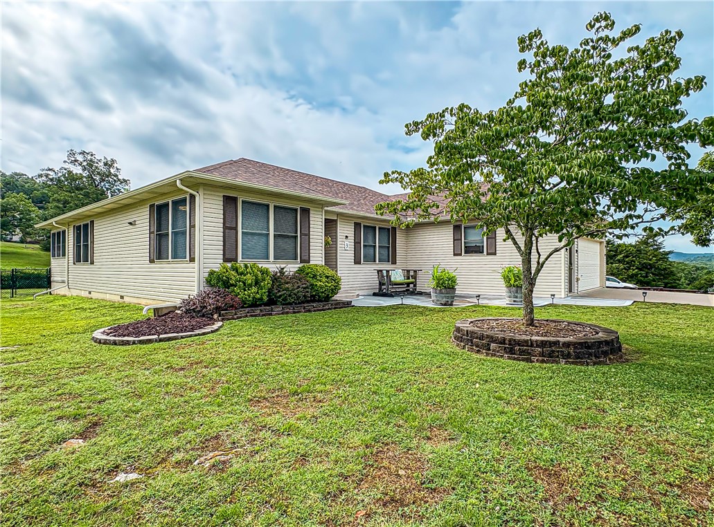 Sitting on 1.55 pristine, park-like acres within walking distance to the Holiday Island Rec Center and Pool, a premier golf course, and just a short drive to Table Rock Lake and the marina. This thoughtfully designed home is full of updates and amenities. As you enter, you will be greeted by a formal entry and spacious living room made cozier by a gas log insert and custom built-ins. The kitchen boasts gorgeous wood cabinetry, quartz countertops, tiled backsplash, and stainless appliances. Relax and unwind each day in the year-round sunroom that overlooks the fenced back yard and acreage with large hardwood trees and abundant wildlife. Down the hall, you will find a guest room with ensuite bath, two primary suites sharing a jack and jill bath with a new walk-in shower and 6x9 walk in closets, along with an open laundry area. Whole house generator and surge protection. HVAC installed in 2020 with transferable warranty. Dual Fuel Heat. Roof replaced in 2023. Water softener. Central Vac. Washer and Dryer to convey.