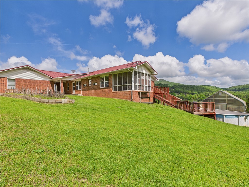 Stunning 6-bedroom, 3-bath brick home, situated on an impressive 67.75 acres of picturesque wooded and pasture land with breathtaking views of the Ozark Mountains. This remarkable property features two master bedrooms, on the main level, each with its own en-suite bathroom, ensuring ample space for comfort and privacy. The interior boasts two kitchens, two living rooms, a spacious walk-in pantry, an office/library, and extra storage/safety room. Outside, enjoy the tranquility of a large pond and the soothing sound of year-round Davis Creek flowing through the property. Additional amenities include a whole-house Generac generator that provides peace of mind, 21x12 metal storage building, a 24x24 greenhouse, perfect for gardening enthusiasts, and a chicken coop. Located on a paved county road, this home offers the perfect balance of seclusion and accessibility, being just 7.5 miles from the Buffalo River and 4 miles from the State Highway. Don't miss this unique opportunity to own a piece of paradise.