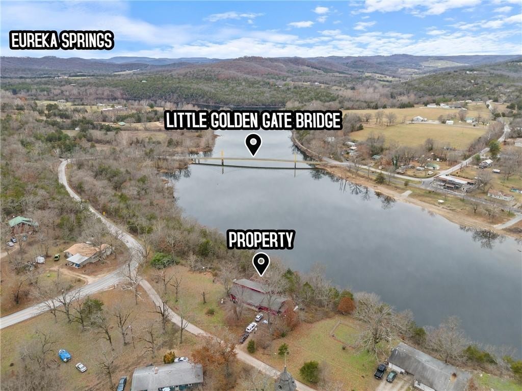 This unique house is perched high above the Beaver Bridge, Table Rock Lake in it's beginning stage, the Beaver campground + swimming areas, boat launching etc. Some of the finest fishing in the area, kayaking, canoeing skiing all at your feet. The house has a huge deck, currently being renovated, looking out at the marvelous view which changes with the weather, season, human activity, all while you are almost invisible. The house is a big open space for LR-DR & K, lots of windows, some w/built in antique stained glass from England, a window seat, fireplace, commercial Wolf stove, built in bookshelves, tile wall tub surround, hardwood floors. Both lots convey, lot 1 has been perked for 2 BD house, has water hookup in place, needs septic. Both large propane tanks are owned &convey.