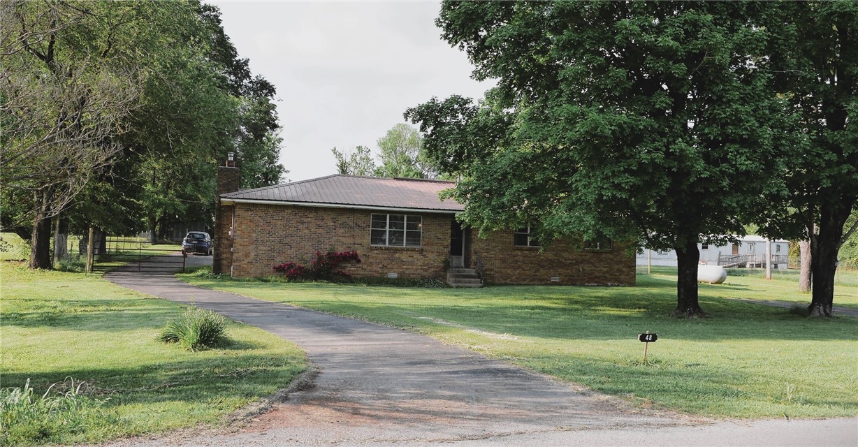 brick home with newer metal roofing, fencing, New paint, flooring and fireplace insert and cap, vinyl wood plank almost an acre, in town yet country feel with beautiful hardwoods Sunken den with beautiful stone fireplace w/New wood burning insert and cap, owner says will heat entire home, This 3 BR 2 BA Brick home with workshop has a pole barn for storage or animals., Newer Central System air propane heat public water. - Large back covered carport or patio. New vinyl plank look flooring, fresh paint and so Clean/Bright w/neutral colors! MOVE IN READY! Great home for a mini homestead Sunny area for garden! Buyer's financing fell through! Over $25K repairs and updates within the past year! call Listing agent for details! 10 minutes from Dogwood Canyon, 25 minutes to Branson West! Selling "as is" at $13k 5 Serious cash or conventional Buyers are a best fit for this home!