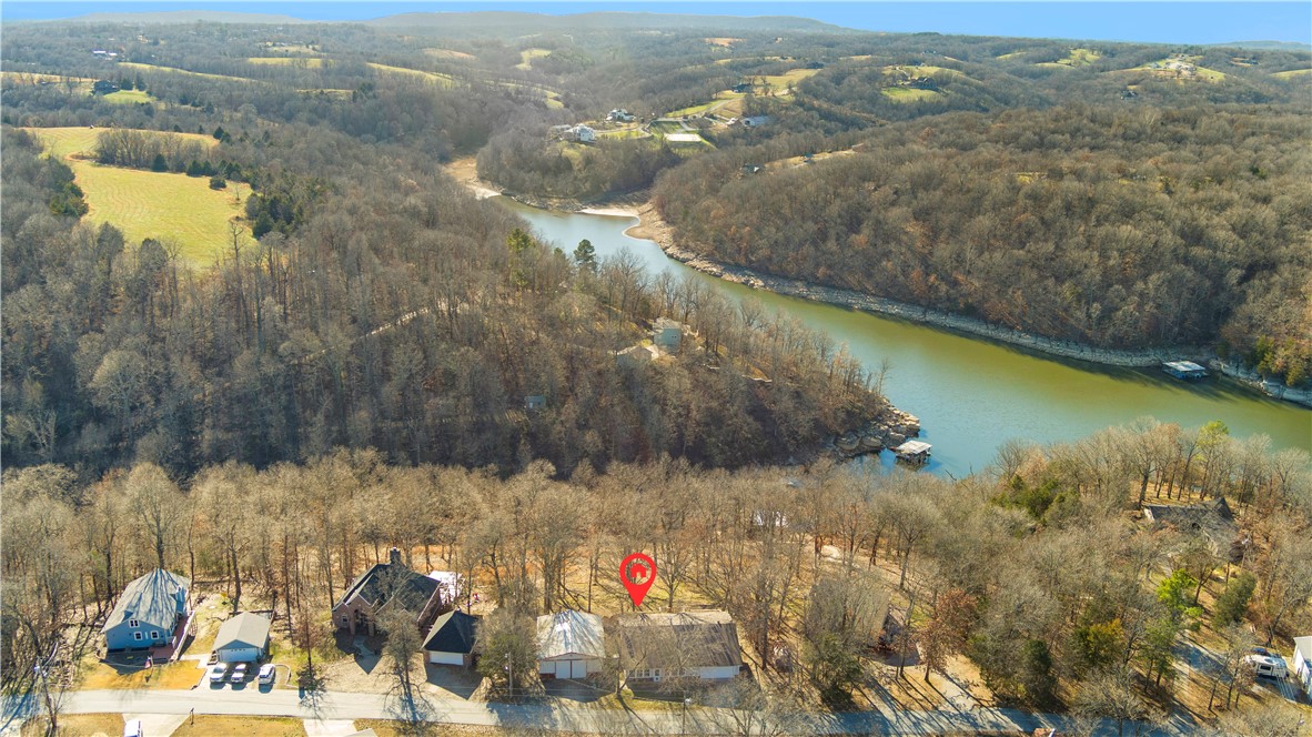 Beaver lake front property situated on approximately 1.5 acres with 150 feet of water frontage. Easy commute into work or entertainment areas in NWA. Located 2 minutes to Hickory Creek Marina. Blueberry Lane features steps leading down from the house to the lake for easy access as well as an easement road to unload kayaks into the lake. Enjoy a 30 X 36 shop with a concrete floor for storing boats, and toys or use for entertaining family and friends. Shop is outfitted for game watching including TV/s, lights for night games and activities. Garage doors open from the front and back to allow for open air feel and outdoor views. This is a perfect investment property for short- or long-term rental. There is plenty of guest parking with 8+ parking spots. Been looking for that perfect lake house? Come check out 12305 Blueberry Lane.