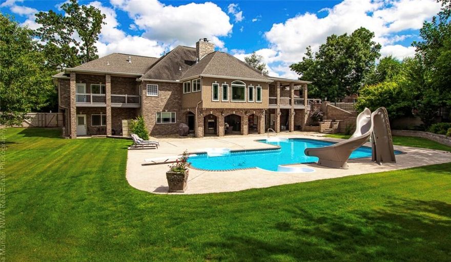 FABULOUS MOVE-IN READY ESTATE ON .96 ACRES WITH BACKYARD PARADISE IN THE HEART OF SOUTHWEST ROGERS!  An entertainer’s dream, this sprawling 3 level home boasts a full guest suite featuring bedroom, living and access to Anne Frank inspired secret passageways.  Main level hosts a gourmet kitchen, private master retreat w/ fireplace and attached office, open formal dining/sunroom overlooking the pool, large living area, private library and more!  Full walk-out basement w/ living room, fireplace, kitchenette, 2 beds, 1 bath and pool access!  Exercise room, large covered patio w/ outdoor fireplace, 40,000 gallon pool, multiple balconies overlooking the pool!  Tons of privacy and green space for kids and pets!  Just minutes from I-49, shopping, hospital, restaurants, entertainment and more!