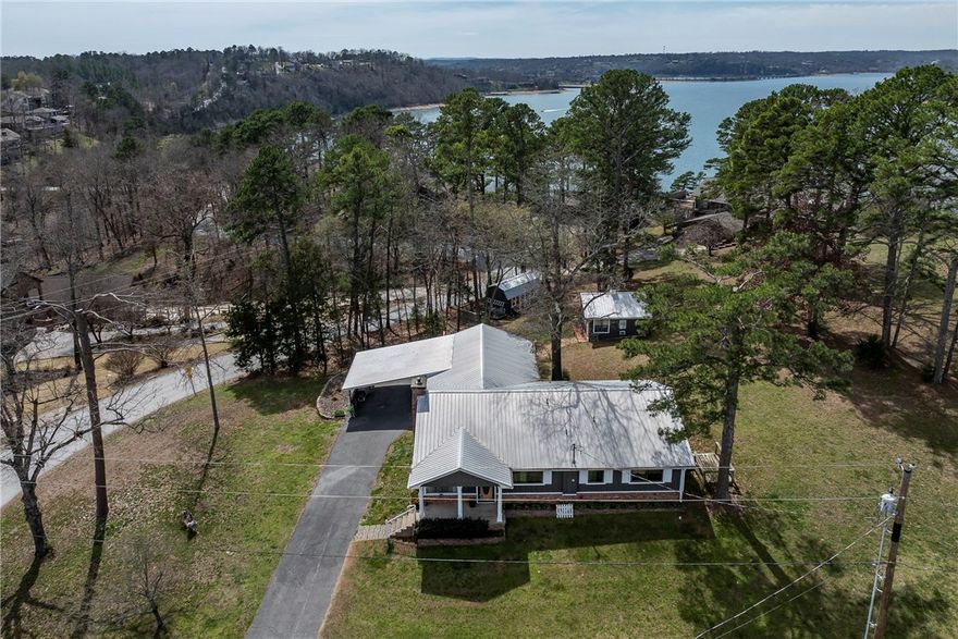 Enjoy Beaver Lake views from this charming 3 bedroom, 3 bath home offering 2,088 sq ft of versatile living on a combined .68 acre lot. Two generously sized bedrooms feature ensuite baths, creating comfort and privacy for guests or multi generational living. A flexible bonus room adds options for a second living area, game room, or media space. A separate detached building expands the possibilities as a home office, hobby room, or art studio, plus an additional storage shed for tools and lake gear. Start the day on the brand new deck and take in peaceful lake views and quiet mornings. Located just minutes from Prairie Creek Marina, Highway 12 boat ramp, Downtown Rogers and bike trails. This property combines everyday comfort with easy access to boating, fishing, and outdoor recreation