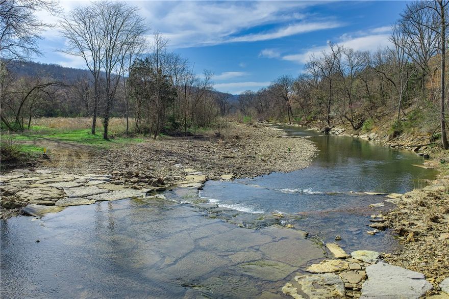Special opportunity to own almost 7 acres of the West Fork of the White River. Travel through a gated, paved entry to your river front paradise. Experience life on the river - fish, swim or just relax. Use the fortified, low-water crossing to reach the other side where you will find pasture and old home sites. Buyer benefits from recent stream embankment restoration.  Convenient location where West Fork and Winslow meet off Hwy 71. Buyer responsible for verifying utilities. River side only. Subject to lot split.