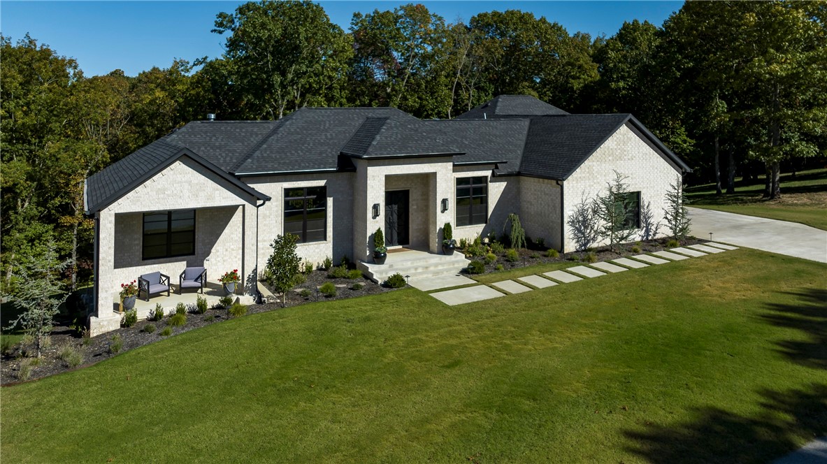 Peaceful sounds of rustling trees and chirping birds will be all you hear sitting outside on one of the patios or deck areas of this stunning custom build. Luxurious estate home with the cozy feel of country living.
Every high end detail so well thought out. Gas light sconces and double iron doors invite you into this gorgeous one of a kind home. Open floor plan with an amazing wooded view from inside. 2 bedrooms on each level. (1) 35' RV/boat garage with hookups. (2) car garage is oversized and there is (1) utility garage downstairs. Game / theater room downstairs with wet bar, home gym, yoga or storage room. Primary suite closet access to the laundry room. Walk in panty off of the kitchen. Multi room audio, surround sound, programable Lennox thermostats for precise control. Extensive security system. The upgrades are numerous. See amenities sheet for more! This wooded estate is minutes to Prairie Creek, downtown Rogers and shopping.