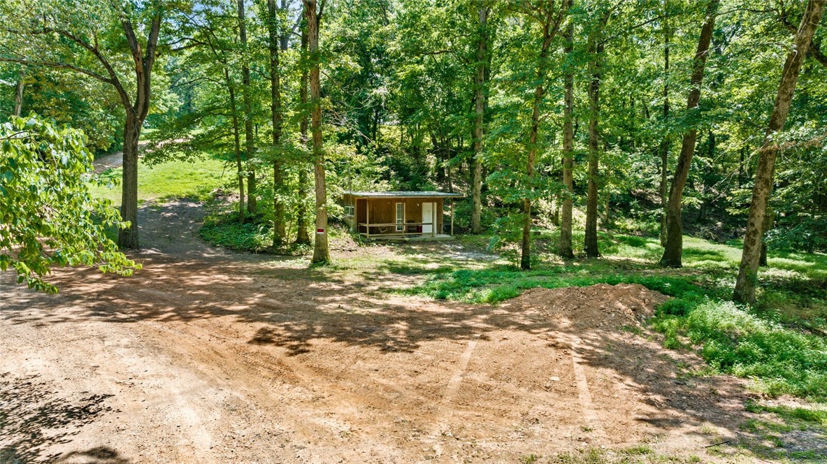 Secluded Oasis on 6 wooded acres: Northwest Arkansas living at it's finest. Escape to your own private retreat nestled on 6 acres of picturesque wooded land in a tranquil rural setting. Abundant wildlife and mature trees create a natural sanctuary, providing unparalleled privacy. Enjoy the peace of the country living without sacrificing convenience. This property is just a short drive from all the amenities, culture and outdoor recreation that NWA has to offer. Build your dream home or a peaceful getaway on this unique parcel.