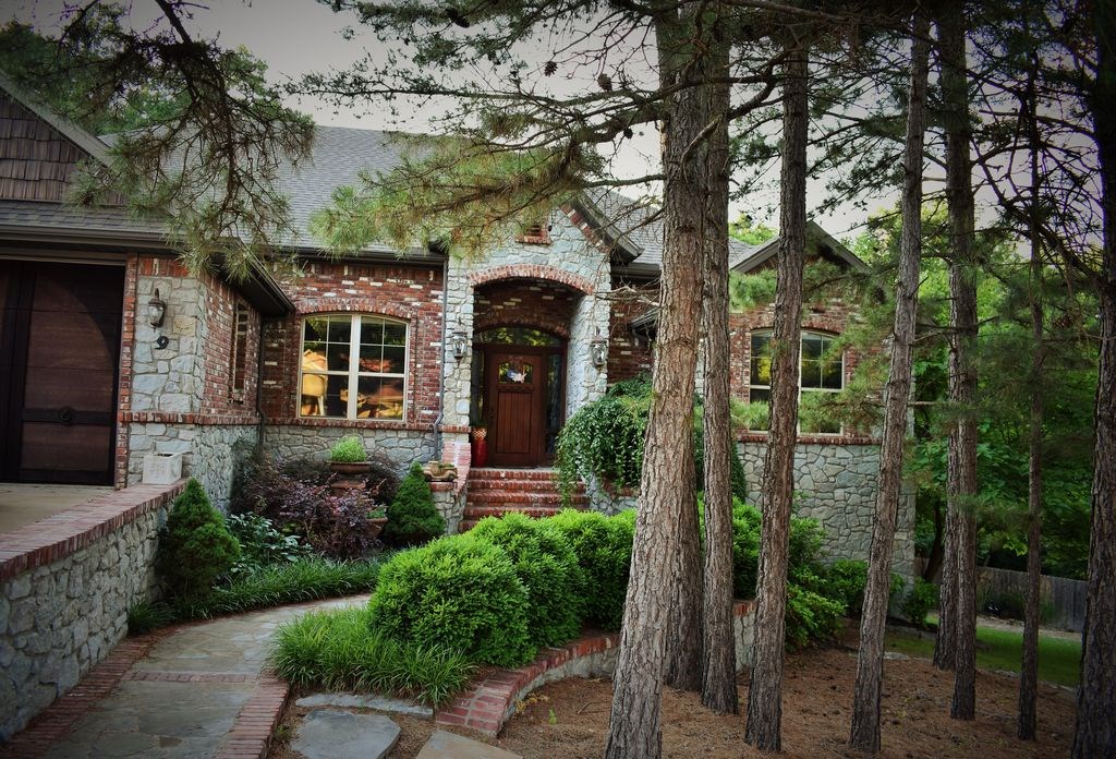 Elegant 6 bedroom home with plenty of room for family and entertaining. Stone fireplace, granite in kitchen, double ovens, hardwood floors, and crown molding. Separate dining area. Separate family room downstairs with patterned concrete floor and bar area. Enjoy outdoor entertaining with the above ground pool and outdoor fireplace. Rustic feeling home with rich wood work throughout and pine trees on the land. Bedroom could easily be made into an office. Located on two lots in Bella Vista, this property backs up to the Bella Vista trails and has an accessible golf complex and skills park.