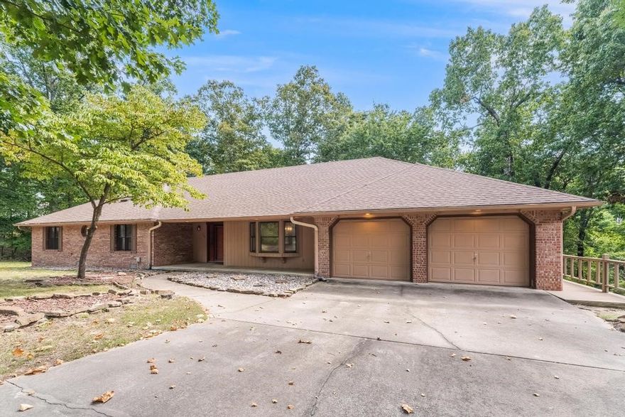Single story all brick home located on 1.5 acres in a Hyland Park cul-de-sac, close to Downtown Rogers & Prairie Creek Marina. Relax on the front porch or the deck that wraps around the entire back. The large living room has a cathedral ceiling, 2 skylights & a wood/gas burning fireplace. French doors separate the living room from the kitchen. Kitchen features granite counters, eat-in kitchen, built in desk & a beautiful bay window over the sink with views of the wooded backyard. Off the kitchen is a pantry & over-sized laundry utility room w/ half bath & tons of cabinets. At the front of the house, there is a very large bonus room w/ bay windows that can be used as a dining room, office or second living space. The primary bedroom includes access to the deck & ensuite area w/ vanity & walk-in closet. The other two bedrooms are oversized w/ large closets & one connects to the 2nd bathroom. Under the deck is access to an enclosed storage room w/6ft clearance. Roof was replaced approx. 6 years ago. Septic pumped 2023.