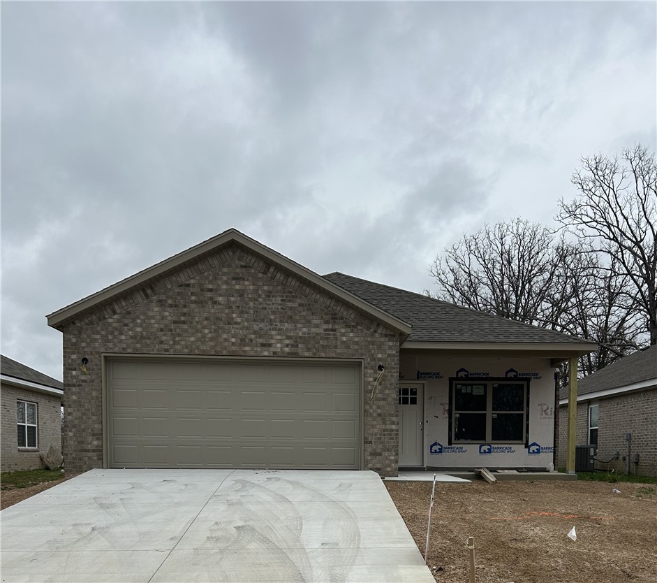View of front facade with a garage, brick siding,
