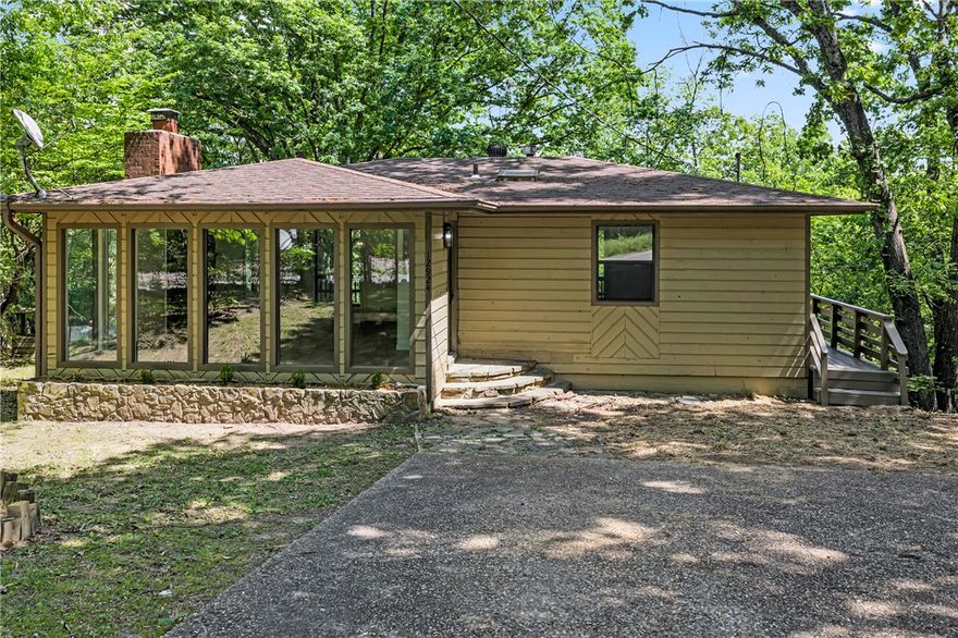 Tucked away on 1.8 wooded acres in Garfield, this charming 2-bed, 1-bath home offers the perfect blend of privacy and lake lifestyle. Comes with a year round lake view and with Beaver Lake just 3 minutes away in either direction, Lost Bridge Marina only 5 miles out, and Beaver Lake Sailing Club 7 miles down the road, outdoor adventure is always within reach. Inside, you'll find a completely remodeled interior with a functional layout, plus a basement bonus room ideal for a workshop or hobby space. A large circular drive welcomes you home, and an expansive deck sets the stage for outdoor living with the right personal touch. Laundry is conveniently located in the basement, and the home sits on public roads for easy access. Sold as-is, where-is, with no seller disclosure — this is your opportunity to own a slice of NW Arkansas lake country.