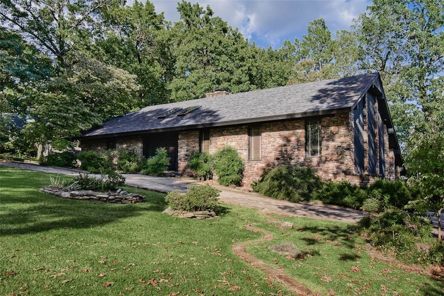 Beautifully maintained Mid-Century Modern home featuring 3 bedrooms and 3 baths, perfectly situated on a stunning wooded lot. The private primary suite is spacious and offers both interior and exterior sitting areas. Each full bathroom showcases marble vanities, baths, and showers. Surrounded by mature trees and lush, thoughtfully designed landscaping, this home offers a serene, natural setting and is located just minutes from Lake Fayetteville, schools, parks, trails, shopping, and dining. The lower level provides a versatile entertainment area with separate access. Additional highlights include an oversized garage, concrete safe room, cedar-lined closet, and a spacious attached storage area — combining comfort, character, and function in this truly special property.