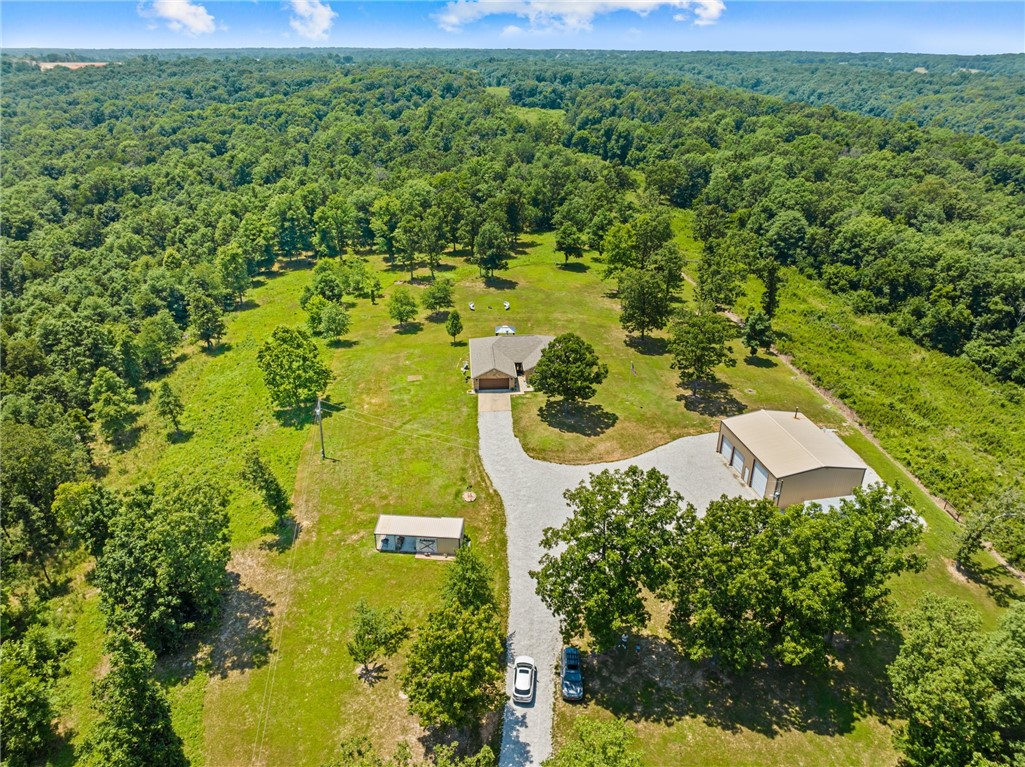 This beautiful 4 bedroom, 2 bath brick home is situated on 5 acres of secluded, wooded land, offering the perfect blend of privacy and natural beauty. The open concept floor plan is perfect for entertaining, with a spacious living room that flows seamlessly into the dining area and kitchen. The kitchen boasts modern appliances, ample counter space, and plenty of storage. The bedrooms are generously sized, with plenty of closet space and natural light. The home also features a large laundry room. Outside, the property is a nature lover's paradise, with plenty of space to explore. The 2000 square foot workshop is perfect for those who love to tinker or need extra space for storage or hobbies. The property is also home to a variety of wildlife, making it the perfect place for nature enthusiasts.Overall, this wonderful home on 5 acres is the perfect blend of modern convenience and natural beauty, offering the perfect retreat from the hustle and bustle of everyday life.
