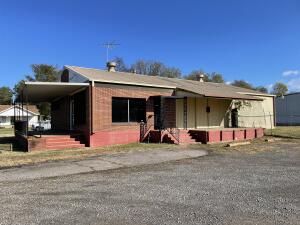 Commercial building with lots of potential. This building is situated on a corner lot with large fenced in area already complete. Main building features 800 sq ft of office space and 1600 sq ft of shop/warehouse space with loading dock. Second detached building that could be utilized or rented is 800 sq ft with roll up door.