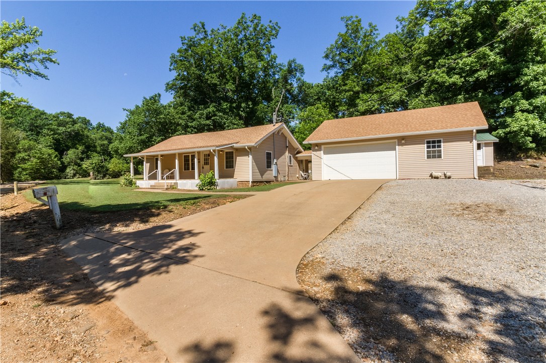 Entirely remodeled home on 1.94 acres across from creek. Newer 32'x28' detached 2 car garage w/ additional 40'X30' workshop boasting 2 oversized overhead doors for parking, storage, or just tinkering. Kitchen has granite counters, wood floors, & abundant cabinet space. Screened-in back patio is perfect for enjoying the outdoors. Only 30 minutes from Downtown Fayetteville!