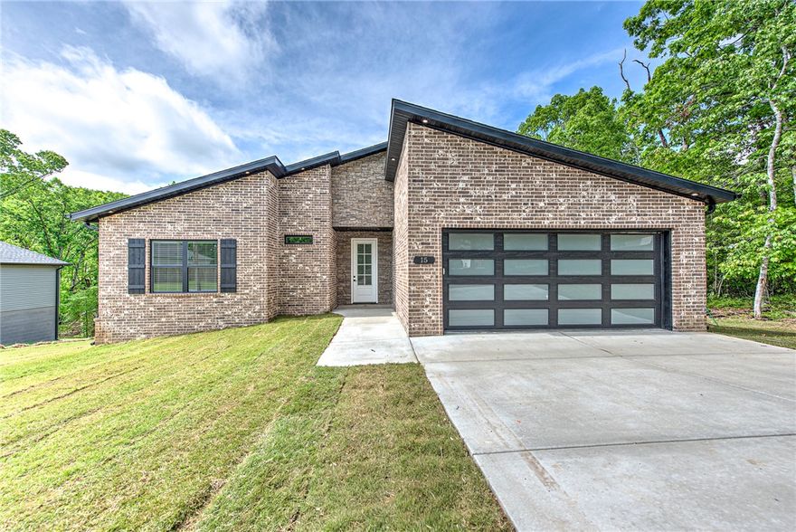 Brand new 3 bedroom, 2 bathroom home with 2-car garage located in desirable Bella Vista, Arkansas. This thoughtfully designed new construction offers an open-concept layout w/luxury vinyl plank flooring throughout the main living areas and a bright, neutral color scheme. The spacious living room flows into the kitchen and dining area, creating an ideal space for entertaining or everyday living.The kitchen features modern cabinetry, stainless steel appliances, ample counter space,& a center island w/ bar seating. The primary suite includes a private en-suite bathroom & generous closet space, while two additional bedrooms are perfect for guests, family, or a home office.Enjoy the peaceful wooded surroundings from the back deck. Additional highlights include a 2-car garage, energy-efficient construction, recessed lighting, and low-maintenance exterior materials. Conveniently located near Bella Vista’s golf courses, lakes, trails,& amenities, this move-in ready home offers comfort, quality,& the Bella Vista lifestyle