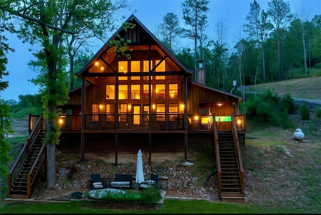 Lakefront Cabin with Treehouse Vibes in Private “Rope Swing Cove”! Incredible Views, Easy Steps to the Water, & Brand-New 26’ Private Dock with Covered Swim Deck, Sunning Area, New Lift & Solar Setup. This 2BR, 2BA + Loft Cabin sleeps 10 & has been a Successful Airbnb for 5 Years. Soaring Tongue & Groove Pine Ceilings in Great Room & Covered Deck, Huge Kitchen with Wood Board Ceilings in Kitchen Nook & Primary BR. Massive Vaulted Covered Deck with Ample Seating—Perfect for Entertaining. Concrete Patio with Firepit & Stone Path to the Dock and Low Corp Line. Unique Rock Bluffs right in Front add to the Charm. Surrounded by Nature—Peaceful & Serene, with Hobbs State Park across the Cove for Unspoiled Views. New HVAC, Asphalt Driveway, & Community Boat Launch at end of road. Minutes to Rocky Branch Marina, War Eagle Cavern & Biking Trails. Ready to make some magical memories at this lake retreat?