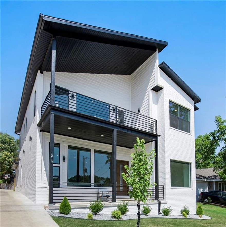 Modern design meets everyday ease in this Briar Town home just moments from the trails and Crystal Bridges. From the moment you enter, soaring ceilings and natural light create an open, elevated feel. The kitchen anchors the home with a large island, professional-grade gas range, built-in 72" refrigerator/freezer, and walk-in pantry with coffee bar. The main-level primary suite offers a spa-like bath and a spacious walk-in closet with private washer and dryer. Upstairs features a second laundry room, three bedrooms, two full baths, and a large family room with surround sound and balcony access. Enjoy the extended patio with sleek firepit and a three-car garage with ample storage. Conveniently located near trails, Crystal Bridges, Airship Coffee, and less than a mile to the Bentonville Square. A thoughtful blend of design, function, and location that simply lives well.
