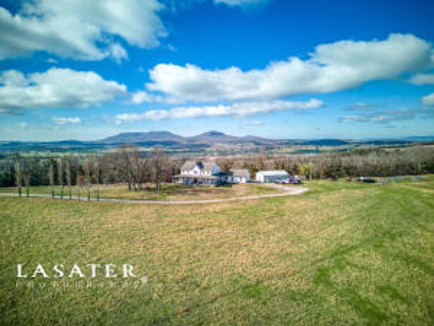 Beautiful 4,904 sf two story, 6 bedroom, 4.5 bath farmhouse style home with full basement on 36 acres m/l of lush pasture for your animals, gardens or greenhouses. This home boasts elegant hardwood floors, an impressive fireplace and quality finishes throughout.  Basement has additional kitchen. This property also features a covered front and back porch, basketball court, pool with a large deck, detached two car garage and a 30x40 workshop with a bathroom. It is conveniently located close to Harrison and Valley Springs.
