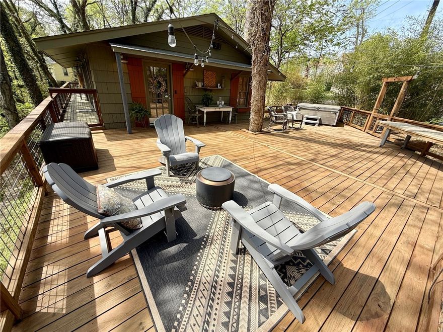 An expansive front deck surrounded by trees sets a tranquil tone for this completely remodeled 3 BR/2.5 BA cottage that feels like you are in the woods. A French door opens into a foyer featuring an art wall flanked by openings to the dining area. A gourmet kitchen with an island features butcher-block counters, custom cabinetry, and built-ins. The living room has three walls of windows that make it feel like a treehouse, with a cozy gas-log fireplace. The main-floor ensuite bedroom is spacious, and the bathroom features a walk-in shower and a vanity with two glass bowl sinks. A powder room completes the main floor. The lower level has a sitting area, two bedrooms, and a full bath. There’s also a laundry room and a bonus room. The carport has a storage room, and there’s space for two more cars in the driveway. You’ll enjoy the Crescent Park neighborhood with a concrete walking trail providing a shortcut to your favorite downtown shopping and dining. Relax after an adventurous day on your deck or in the hot tub.