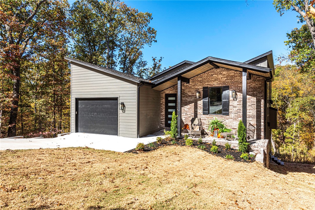 Discover luxury living in this brand-new modern home. The 3-bedroom, 2.5 bathroom residence showcases premium features throughout two HVACs with smart Ecobee thermostats. The gourmet kitchen boasts leathered granite countertops, a scratchless composite undermount sink, and soft-close cabinetry. Elegant touches include concrete quartz surfaces and Delta fixtures. The master suite features a curbless shower, while an energy-efficient tankless water heater and insulated 8-foot garage door with belt drive opener add practical value. Spacious walk-in storage area under the house provides abundant storage. Custom metal railings on both outside decks and interior stairs. Property backs to Tunnel Vision Trail and is just a five-minute walk to Lake Avalon. As part of the Bella Vista community, enjoy access to all POA amenities, including golf courses, lakes, pools, tennis courts, and recreational facilities. This masterfully crafted home combines modern luxury with practical amenities in a sought-after location.