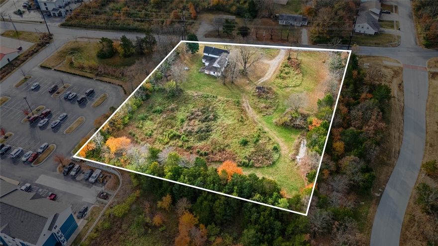 Prime 2-acre C2 development opportunity directly adjoining Centennial Mountain Bike Park—one of Fayetteville’s premier outdoor tourism destinations with 228+ acres of world-class cyclo-cross and mountain biking trails. This site is surrounded by rapid commercial expansion, including national-brand hotels, multifamily communities, restaurants, and self-storage, making it ideal for large-scale commercial growth. With immediate proximity to I-49 and positioned in one of Fayetteville’s fastest-growing corridors, this property is perfectly suited for hotel development, branded extended-stay concepts, multifamily housing, or a mixed-use project capitalizing on strong year-round visitor traffic. Direct trail access creates a unique value proposition for hospitality and residential developers seeking NWA outdoor recreation economy. Property includes a historic structure (“The Old Tharp Place,” circa 1844), offering optional restoration potential or integration into a creative development plan. Please reference 1329056