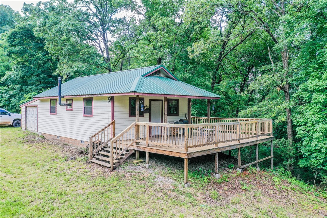 Escape to your own private paradise with no neighbors in sight on 40 acres with pond, plenty of wild game, a cabin that is wired and plumbed with access to electric and water, a large deck on two sides to sit and watch the wildlife and just relax and enjoy life without all the hustle and bustle. Located only 30 minutes from Fayetteville and 15 minutes from Devil's Den's State Park, this property is perfect for enjoying all things outdoors but also a convenient drive to shopping and shows. This place will make the perfect weekend retreat or country setting for your future dream home. Call today for your private showing.