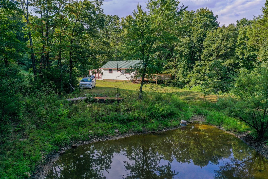 Escape to your own private paradise with no neighbors in sight on 40 acres with pond, plenty of wild game, a cabin that is wired and plumbed with access to electric and water, a large deck on two sides to sit and watch the wildlife and just relax and enjoy life without all the hustle and bustle. Located only 30 minutes from Fayetteville and 15 minutes from Devil's Den's State Park, this property is perfect for enjoying all things outdoors but also a convenient drive to shopping and shows. This place will make the perfect weekend retreat or country setting for your future dream home. Call today for your private showing.