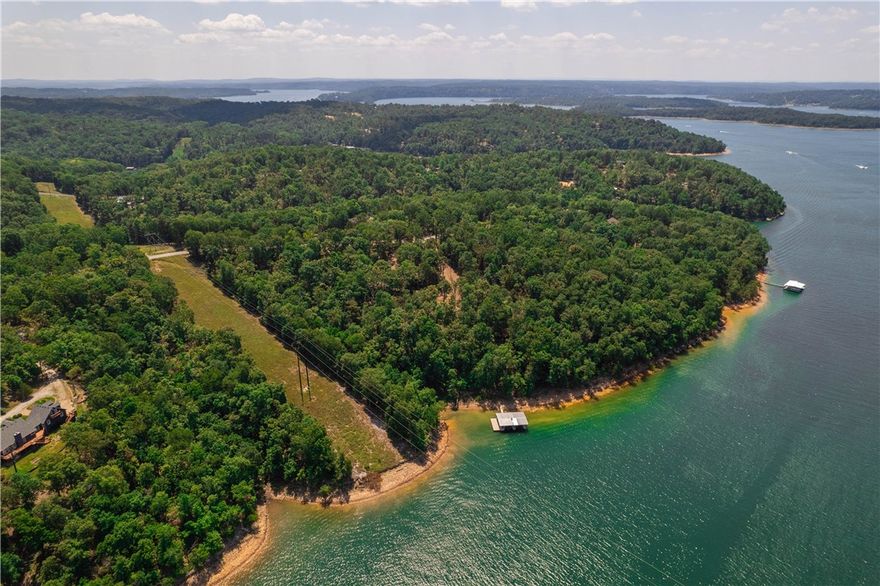 LAKEFRONT living on 4.57 acres with a PRIVATE 2-slip dock, new boat lift & 2 jet ski lifts. The dock is updated with solar power, composite decking, and a swim deck—perfect for easy lake access. Located in popular Coose Cove, you're 20 minutes from downtown Rogers’ nightlife and a 5-minute boat ride to Prairie Creek Marina. Your backyard is a gateway to boating, fishing, and water fun, with a concrete path to your dock making it easy to transport everything you need for a day on the lake. Enjoy breathtaking sunsets and evenings around the fire pit under a starlit sky. The home features natural flagstone floors and expansive decks for soaking up lake views. The open kitchen leads into the living area and a screened deck, ideal for gatherings or serene mornings. Each bedroom has its own ensuite bathroom and deck access, ensuring privacy and comfort. Perfect as a serene lake home or turnkey investment, this property invites you to make unforgettable memories. Ask for full list upgrades. New HVAC Mult. building sites.
