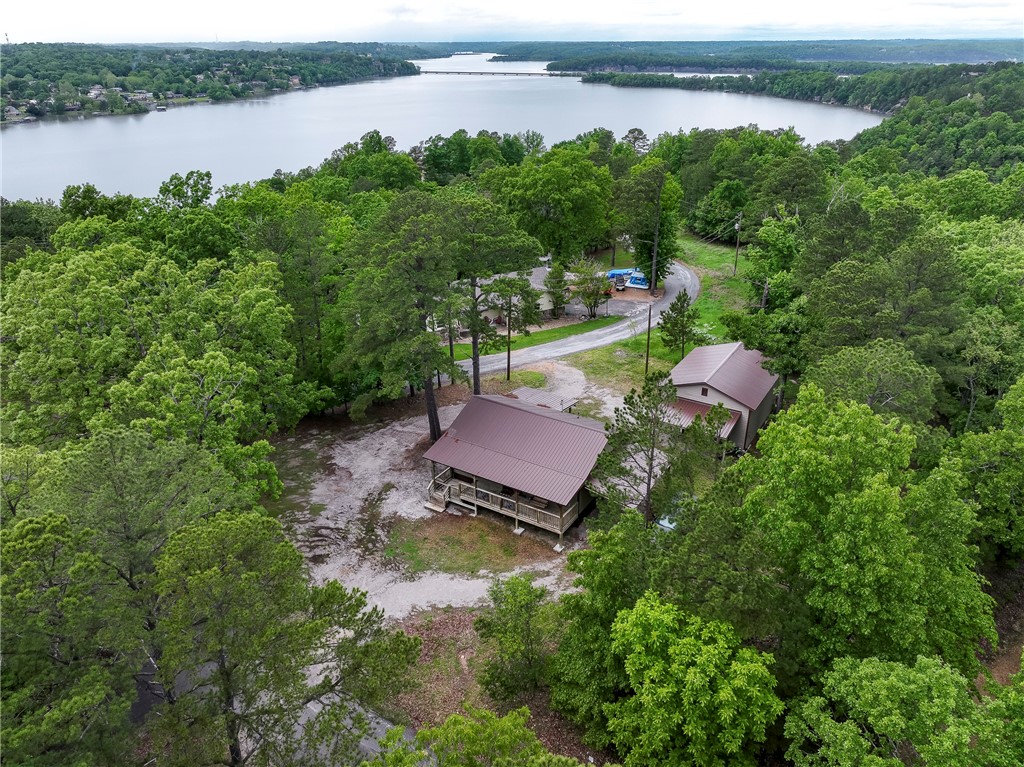 Possibilities abound. Look no further for your wonderful home that’s within minutes to Beaver Lake and all that downtown Rogers has to offer. This country style home has a large covered porch that runs along the front of the house and a beautiful covered deck on the back. It also has two bedroom bedrooms, living room, kitchen, utility room. It has a two car detached garage with a car lift inside and a carport attached to the garage for extra parking. This lovely place would make a wonderful Airbnb since it is so close to beaver lake. Don't let this one get away!