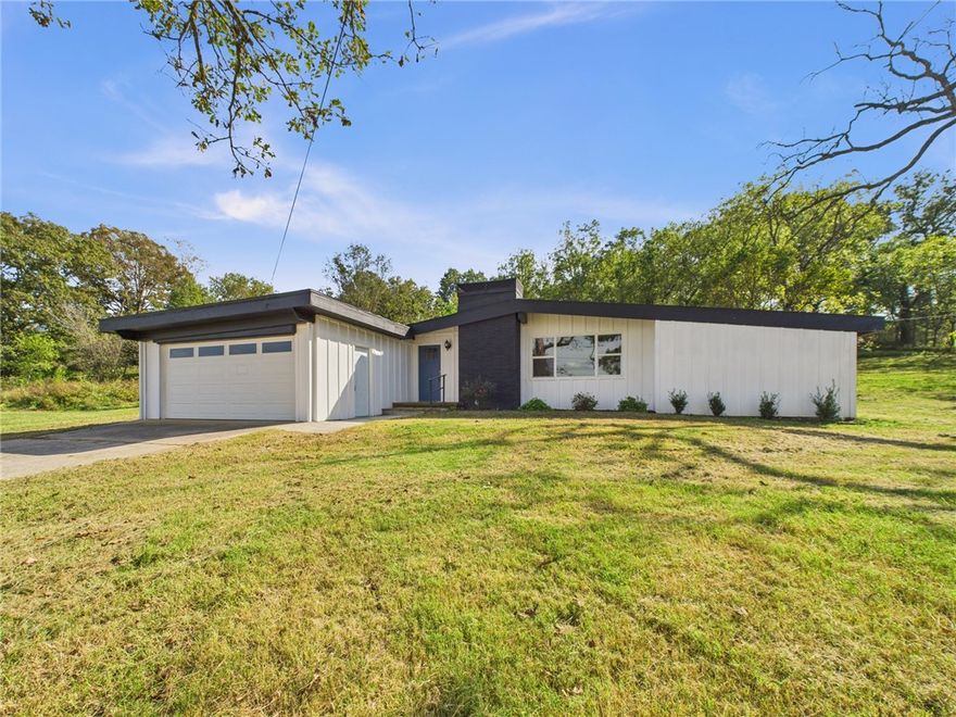 Enjoy the best of both worlds—modern comfort and peaceful country living—at 14257 Osage Creek Road in Springdale, AR! This renovated mid-century modern home sits on 2.63 acres just outside city limits near Tontitown. Updates include a new roof, new septic, new luxury vinyl plank flooring, and a fully updated kitchen with stainless-steel appliances and stylish finishes. The open layout flows into a bright four-seasons room, adding extra living space for entertaining or quiet mornings with a view. There’s plenty of room for a garden, chickens, or a horse or two, offering true rural living close to town. Enjoy move-in confidence with a seller-provided home warranty. If you’re seeking acreage, privacy, and a modern feel minutes from Springdale amenities, this home checks all the boxes!