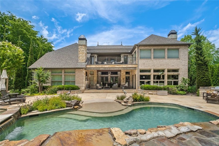 Stunning custom home poised on 2 acres along the White River in fabulous gated subdivision. Meticulously built w/attention to detail & entertainment in mind; this 5 BR home boasts formal & casual spaces, wine room, handsome paneled study, recreation room w/wet bar, game area plus theater room. Detached Art Studio offers fabulous living space w/kitchenette, full bath & loft sleeping area. Incredible outdoor oasis w/covered veranda & FP, resort style pool/spa w/waterfall features & grilling station. Grand entry w/wall of windows flanked by dual staircases. Gourmet kitchen opens to a 2-story family room w/stone FP, spacious eating area, featuring a gas range cook top, island w/prep sink, large pantry, ice maker & Subzero Fridge. Owner's suite w/sitting area & luxurious bath w/glass walk-in shower, coffee bar & separate walk-in closets. Guests will enjoy the main level en-suite. Additional amenities: Hand-scraped wood flooring, Anderson windows, French doors, 4 car garage, workshop, storm shelter, Geothermal & well.