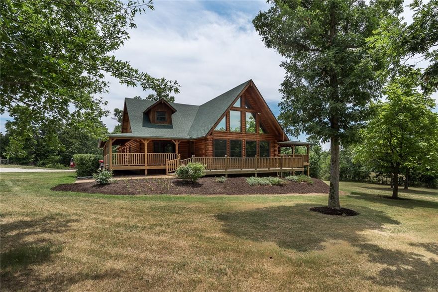 Stunning log home on over 26 acres in Bentonville! Enjoy the secluded setting and convenience of being close to town. Barn and outbuilding provide plenty of space for hobbies and outdoor activities.Fenced paddocks for horses. The home itself is made for entertaining! Brand new roof, refinished exterior and interior wood, new carpet.Living room has vaulted ceilings, and huge windows looking out to beautiful scenery. Formal dining room. The kitchen is truly the heart of the home with  two massive islands, gas range, built-in appliances, and abundant cabinet space. The kitchen opens out to the large covered deck. Multiple outdoor living spaces are perfect for relaxing and entertaining. Huge basement has family room with fireplace, large wet bar area, exercise room, media room, and space for game room or home office. Exercise room wired to convert to sauna. Master suite has spa-like attached bath. Three guest bedrooms. Six total parking space available. This property is a MUST SEE!