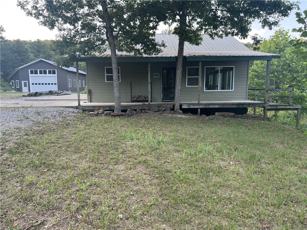 PRIVATE secluded home plus a 62'x40' guest house/workshop on 60 acres!!! Very close to the Buffalo River National Park. This comfortable country home features 2BR-1BA, wood stove heat, cathedral ceilings, loft area, walkout basement bedroom, 3 decks, 8x32 covered porch overlooking the year-round pond, and calming country views. MUCH more than an expansive workshop, the 2,480 SF shop building is rustically finished with 3BR-1BA, LARGE loft, wood stove, lovely wood walls, utility room, partially finished kitchen room, and plenty of room for guests!!! 60 acres includes approximately 5 acres of pasture, LOTS of wildlife, and a YEAR-ROUND SPRING that is piped and gravity flows into the house for water (home also has a water well). Plus a 16x24 storage barn with 15x24 attached lean-to. This is a Preppers dream property.