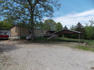 Large mobile with a 20 x 30 shop on 16 lots within 1/2 mile to the lake! This is a great weekend property close to the lake with four wheeler trails cut throughout the property. There is a metal carport to protect your boat from the elements or you have that 20 x 30 shop to back it in. There is also a great storage shed to put all your lake toys in. Possible owner financing available with a good down.