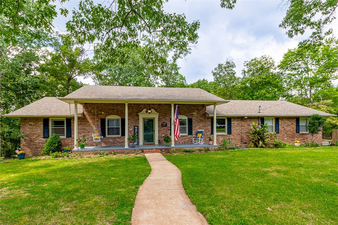 Welcome to 1420 Woodland Drive. This hidden away, peaceful neighborhood offers the best of Rogers! Just minutes from town and Beaver Lake with large lots and easy living. Your new home offers 4 bedrooms, 2.5 baths & 1.68 acres with woods at the rear of your back yard. Rich hardwood flooring, freshened interior paint, a fabulous kitchen with your gas range and spacious pantry. Split bedroom plan with an inviting primary suite which will be your haven. Your sunroom overlooks the lush back yard which is accessible from a lengthy deck and ground level patio. Updates include: roof (2024), tankless water heater, & newer HVAC. With room for your garden and the basketball goal - make this wonderful property your home!